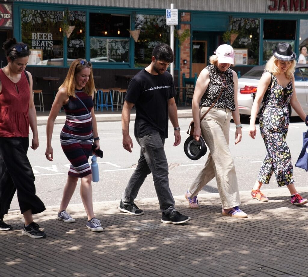 Teams completing a box step challenge, all doing a synchronized dance move 