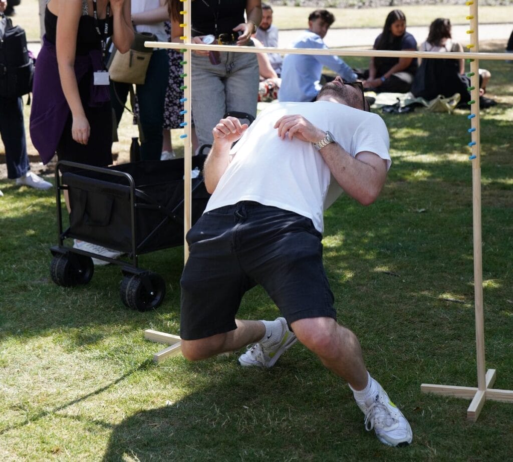 a player does an impressive limbo attempt with onlookers in the park
