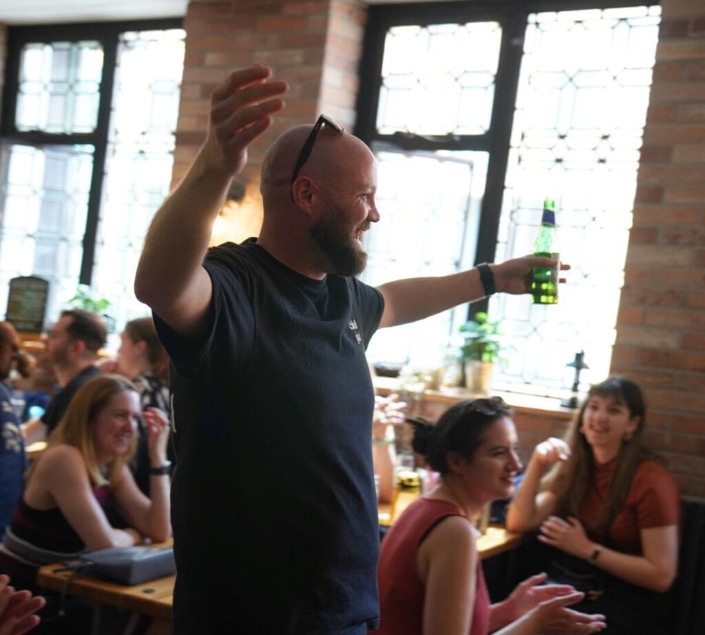 Chris Rogers from Education Cubed looks joyful, holding his beer as he goes up to collect his prize