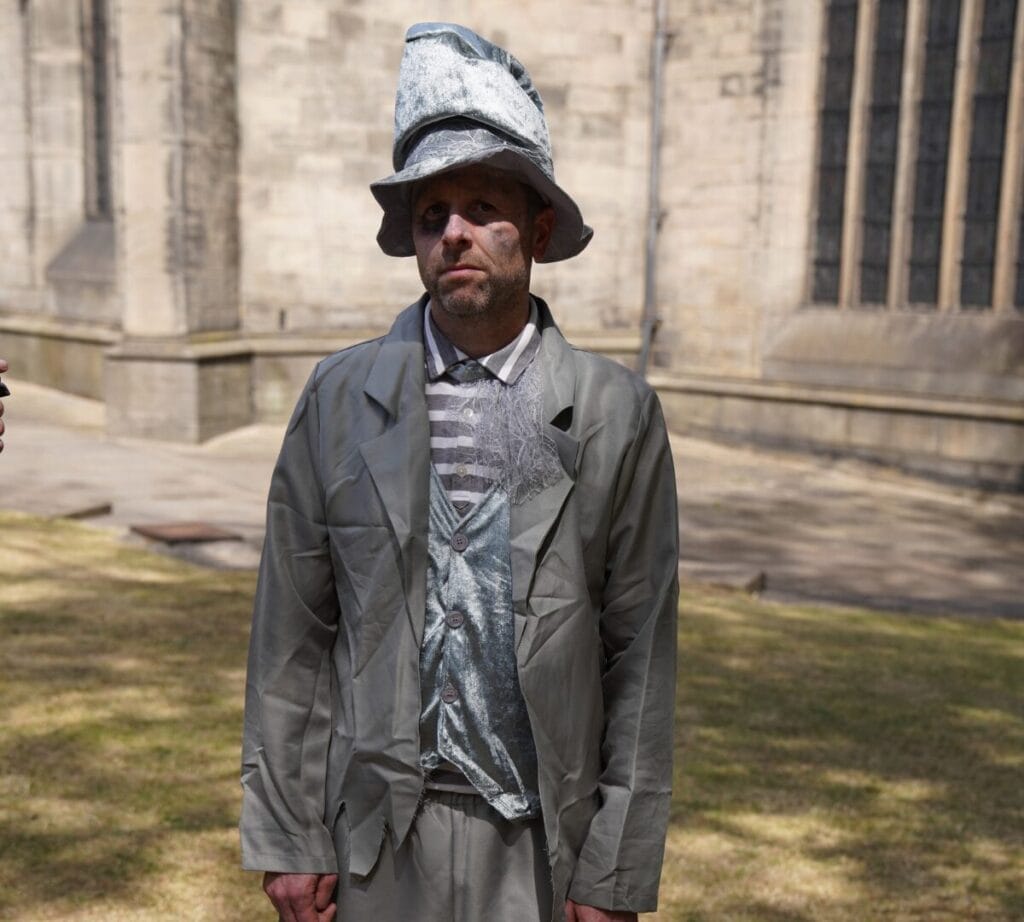 Andy Holliday dressed as a ghost, with face paint on, looking a bit sad.