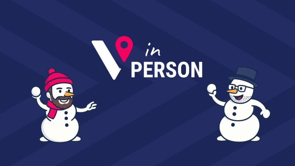 Two cartoon snowmen—one with a red beanie and scarf, the other with glasses and a top hat—face each other holding snowballs beneath a stylised “V” with a map pin and the text “in PERSON” on a dark blue background.