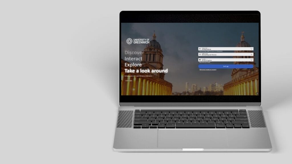 Open laptop on grey background showing University of Greenwich login screen with cityscape backdrop and sign-in form fields.